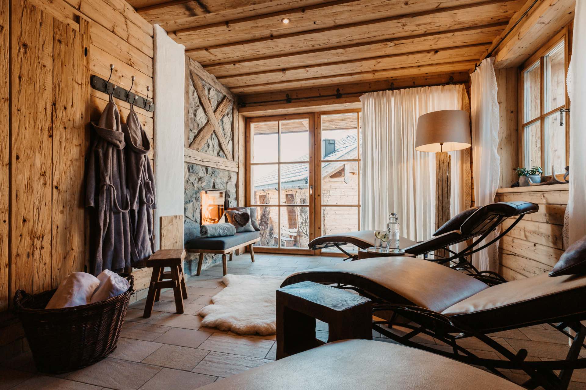 Wellnessurlaub in Österreich - die schönsten Chalets mit Sauna und großem Outdoor-Whirlpool - Ruheraum mit Relax-Liegen und Kamin